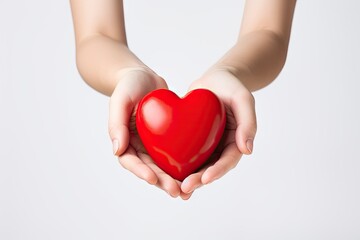 top view of hands holding a red heart isolated on white, a symbol of love, care, and support.