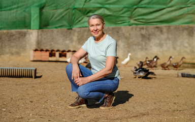 Mature woman on a small chicken and duck farm