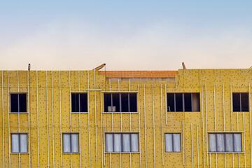 Insulation wall facade of new residential building. Thermal insulation of building wall, decorative exterior cladding. Insulate building with rock wool, installing ventilated facade. Heat saving