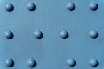 The background texture of the metal on the bridge with rivets painted in blue.