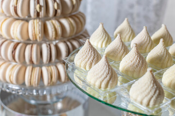 Candy bar. Festive table with tower of macarons and meringue