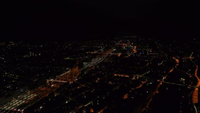 Aerial panoramic view of city at night. Illuminated streets and railway infrastructure contracting with dimmed buildings. Zurich, Switzerland