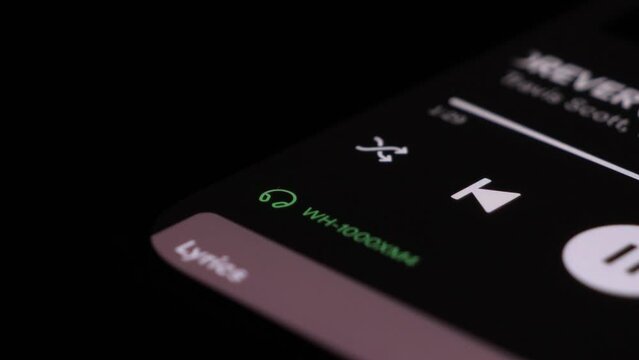 Close Up Shot Of Icons Showing Bluetooth Connection To Wireless Headphones On Spotify App On Mobile Device 