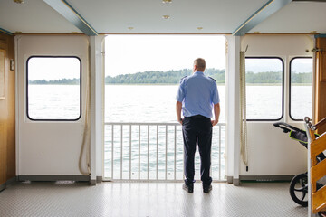 Man looking out the window of a ferry on the Chiemsee Lake in southern Germany