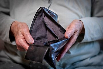 Rentnerin hält leeres Portemonnaie in der Hand
