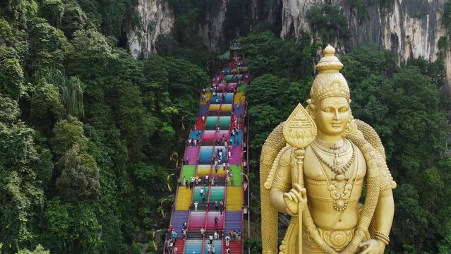 Aerial drone shot of Batu Caves temple and the giant Murugan statue, Hindu God of war, in Kuala Lumpur, Malaysia.