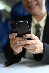 Cropped shot of businesswoman passenger checking work, news on smart phone during flight
