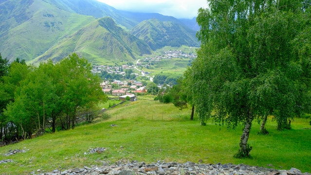 A View to Infinity: The Kazbegi Mountains Rise Above the Clouds, surrounding the small town of Kazbegi Mkinvartsveri in Georgia in a cloudy day in summer, Gudauri gergeti trinty church, ananuri