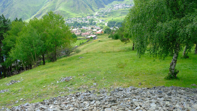 A View to Infinity: The Kazbegi Mountains Rise Above the Clouds, surrounding the small town of Kazbegi Mkinvartsveri in Georgia in a cloudy day in summer, Gudauri gergeti trinty church, ananuri