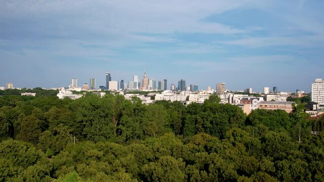 Aerial Panorama of Warsaw Downtown Cityscape  in Backdrop of Lush Green Forest on Sunny Summer Day 