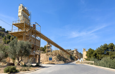 Chalk plant and ready mix concrete. Plant for production of cement and dry mortar. Crushing stones in open pit mining. Industrial plant Farm field in mountains. Orange tree in Spain farm field.