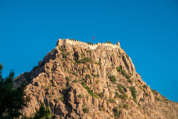 Naklejka premium Afyon castle on the rock in Afyonkarahisar Turkey in front of a sunny blue sky