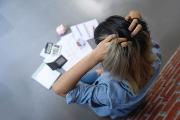 Stressed young woman calculating monthly home expenses with bank account balance and credit card...