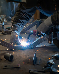 A man welds two pieces of metal together