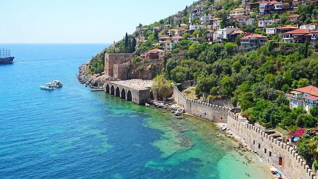 Ancient shipyard or Tersane near of Kizil Kule tower and beautiful beach and calm turquoise sea surface in Alanya, Turkey