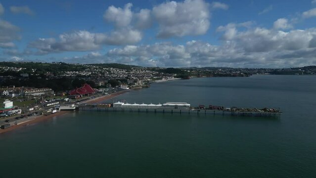 Paignton, Torbay, South Devon, England: DRONE VIEWS: The drone flies towards Paignton Pier from the south showing Paignton seafront with a large Circus Tent situated on Paignton Green.