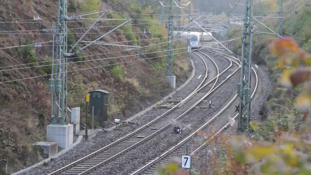 Telephoto view of German ICE train driving through countryside, static shot