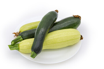 Dark green zucchini and light green marrows on white dish