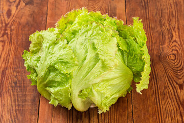 Head of fresh iceberg lettuce on a rustic table