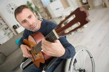 disabled man at home playing the guitar