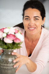 beautiful woman arranging flowers picked from her garden