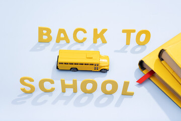 Yellow school bus with books and an inscription back to school. concept photo.