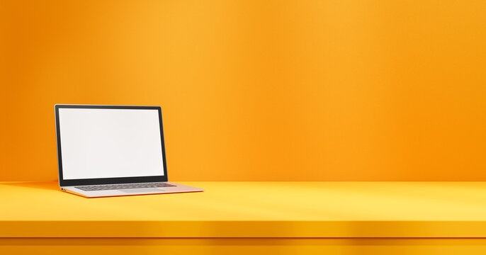 Laptop with white empty screen mock up on yellow table on orange wall backdrop