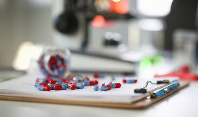 Tablets scattered blue and red color on the table of pharmaceutical laboratory pill for the prescription and treatment various diseases chemistry