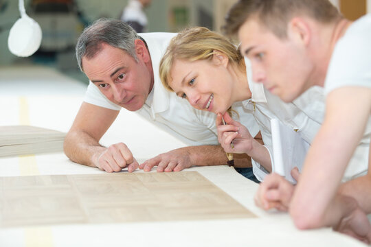 carpenter with apprentice in workshop