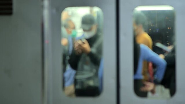 Blurred train passengers on a commuter train at station in Jakarta at night. Depicting the density of train passengers after work hours.