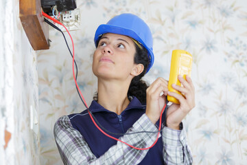 a female worker is measuring electrical current