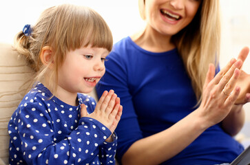 Cute little girl play with mom pat-a-cake at home portrait. Love care friendship parrent casino...