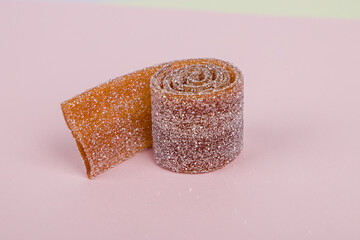 
Brown jelly candies on a pastel pink background.