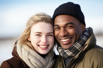 happy, love and interracial couple with smile on beach in winter sunshine together