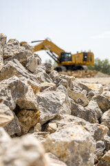 Obraz premium stones lying in front of a big unsharp excavator