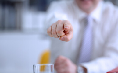 Male arm point forefinger to you or camera during conference conversation in office closeup. Suggestion illustrate offer proposition bribe demand boss advisor idea concept