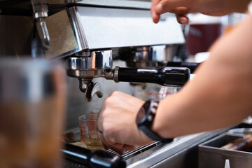 Fototapeta na wymiar The barista makes latte art coffee with an espresso machine