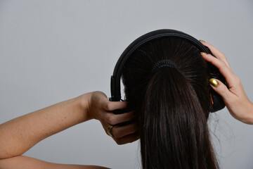 frau hört  podcast musik im kopfhörer mp3 music streaming lange schwarze haare portrait