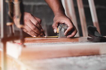 Carpenter working with equipment on wooden table, And measurement of a wooden plank