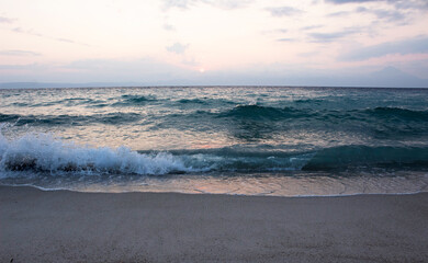 Summer tropical sunrise with waves and cloudy sky.