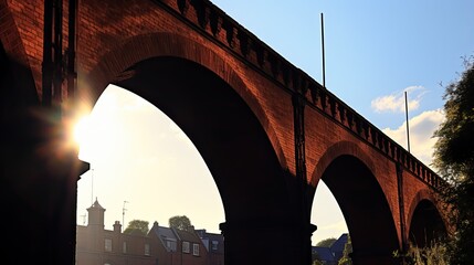 Chimney tops under railway bridge arches on homes below the red brick train arches silhouetted on a...