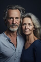 studio shot of a mature man and woman standing together