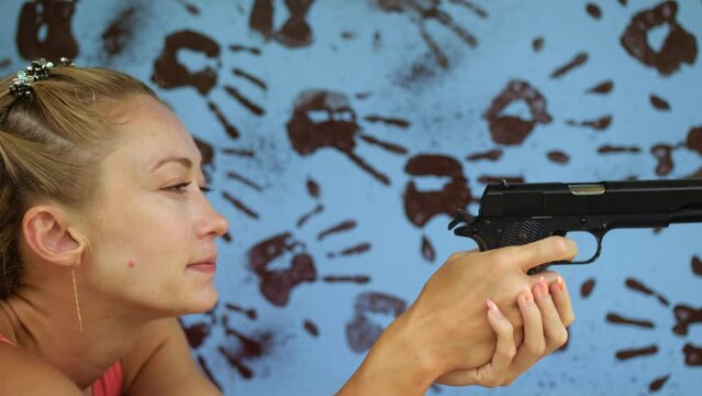 Woman shoots at shooting range with pneumatic gun.Practice in shooting gallery safe legal pistol weapons.Outdoors entertainment for tourists in Thailand.Active leisure on vacation, traveling in Asia
