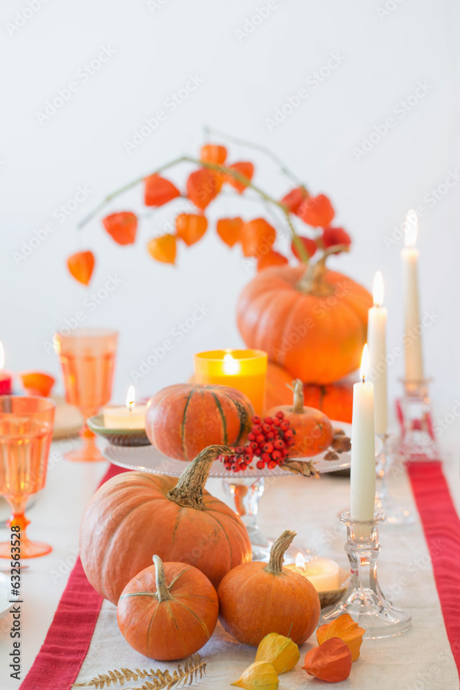 Poster autumn table setting with burning candles and pumpkins