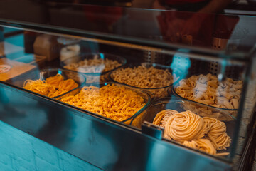 Italian colorful handmade organic Pasta on the shop window, fresh pasta: with squid ink, traditional, with spinach. Italian food. High quality photo