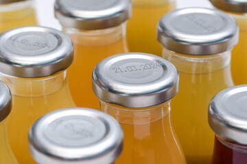 Szklane butelki ze srebrnymi nakrętkami z sokiem pomarańczowym  - obrazy, fototapety, plakaty
