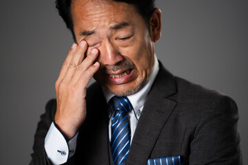 悲しんでいるミドル男性　ビジネスイメージ