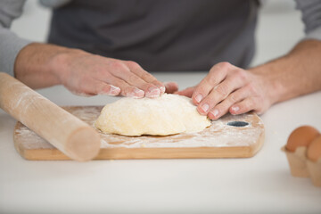 hands with dough and wooden board