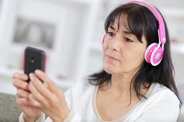Naklejka premium happy senior woman in headphones