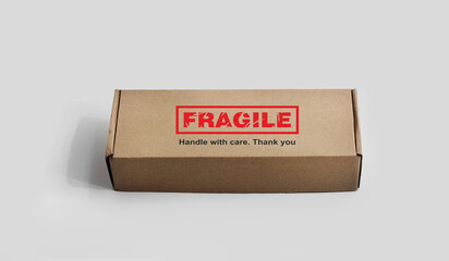 A rectangular cardboard box. Monochrome light background. An adhesive warning labels for packaging - Fragile, Handle with care, Thank you. Red, black, white, beige colors. Textured font design